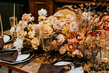 Stylish wedding table setting with flower decor and candles.