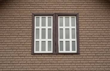 
brown brick wall with a white window in the middle