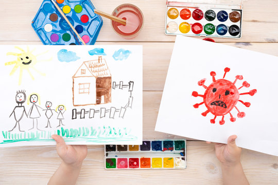 A child draws a coronovirus and his family on a piece of paper. Coronovirus and family at home. The drawing was made by a child using color paints. Children's drawing. View from above
