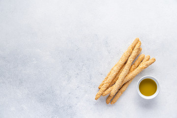 Organic Italian grissini or salted bread sticks and bread lying on a gray background. Fresh Italian snack for apero. Top view, copy space