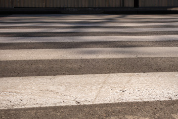 Close-up of a gray and white pedestrian crossing markings.