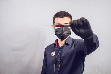 Obraz premium Doctor standing with stethoscope holding a syringe.