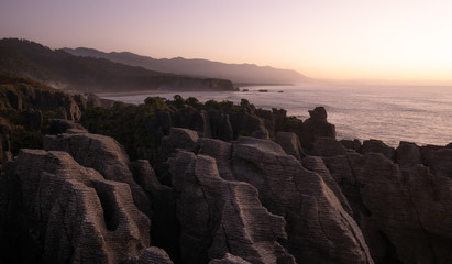 Unusual rock formations on ocean´s coast shot during sunset, Picture made at Punakaiki Pancake Rocks, West Coast, New Zealand