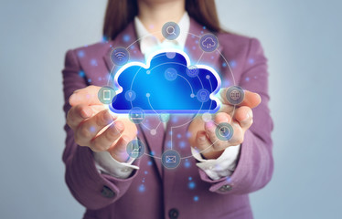 Young woman demonstrating digital cloud with icons on grey background, closeup. Modern technology