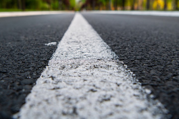 Black asphalt road and white dividing lines