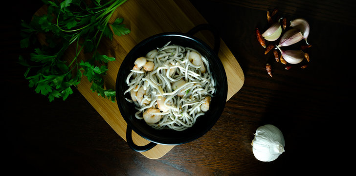 Cacerola de Gulas con gambas, ajos, perejil y guindillas, dark photography cenital