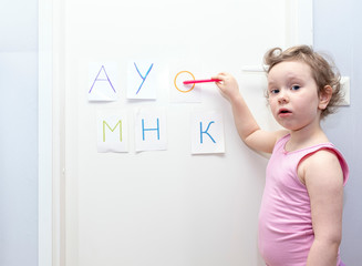 Child, girl preschooler, studying the alphabet at home.
