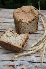 Fresh rye bread or whole grain bread on dark table background. Healthy baked bread in slices, whole homemade bread. Organic farm food. 