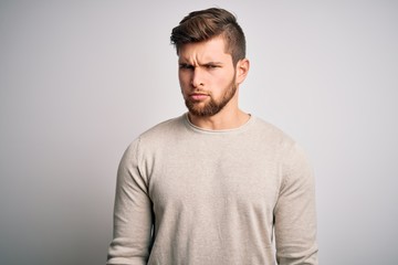 Young handsome blond man with beard and blue eyes wearing casual sweater skeptic and nervous, frowning upset because of problem. Negative person.