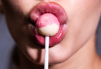 Sexy woman sucks lollipop, close up lips.