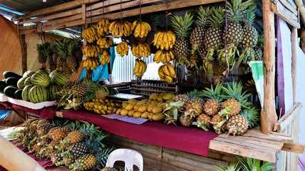 Exotic and colorful fruits in asian market. Bananas,  pineapples, mangos and watermelons.