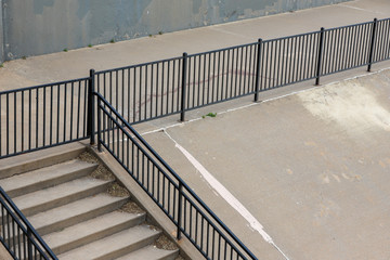 Concrete walking path with stairs and black metal fence