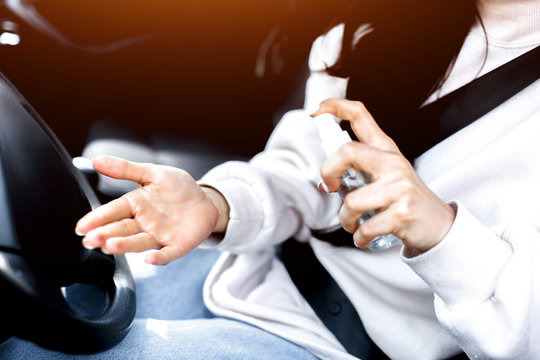 Close-up of a hand. A woman uses a hand sanitizer in a car. It protects against viruses and bacteria. The female model does not want the disease on coronavirus covid-19