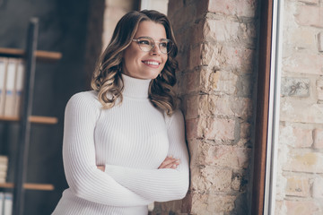 Naklejka premium Close-up portrait of nice attractive cheery dreamy wavy-haired girl executive assistant librarian ceo boss chief employer folded arms in modern loft brick industrial interior style workplace station