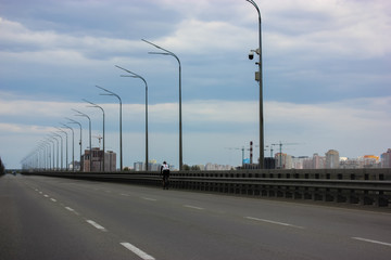 A cyclist rides on an empty road in town.