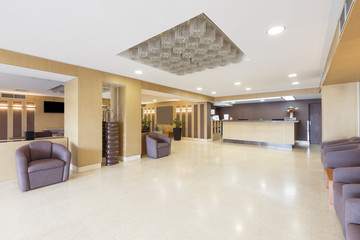 Empty interior of hotel hall with reception desk.