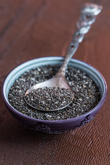 Chia seeds with spoon in the bowl on the wooden background