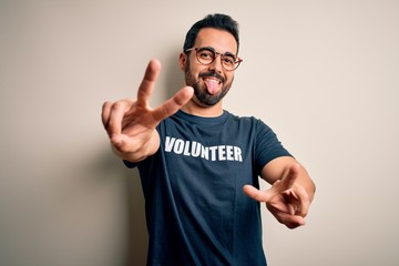 Handsome man with beard wearing t-shirt with volunteer message over white background smiling with...