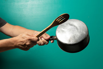 Protest, men with a pan on hand and a woden spoon