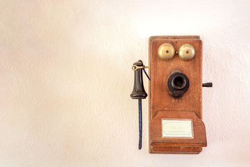 An old wall telephone of the early 20th century on the wall.