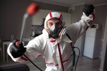 coronavirus disinfection inside the house. The disinfector in the Hazmat cleans the apartment from viruses and infections