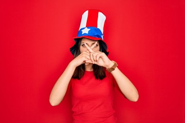 Young beautiful brunette woman wearing united states hat celebrating independence day Rejection expression crossing fingers doing negative sign