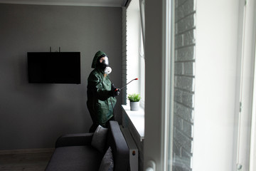 coronavirus disinfection inside the house. The disinfector in the Hazmat cleans the apartment from...