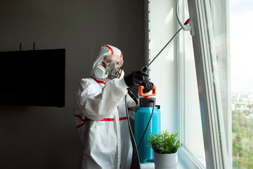 coronavirus disinfection inside the house. The disinfector in the Hazmat cleans the apartment from...