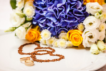 Wedding rings against the background of the bride's bouquet.