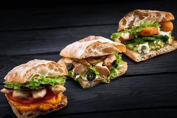 Closeup three different Appetizing sandwiches or burgers on wooden background