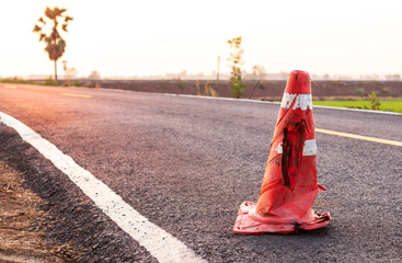 The rubber cone was demolished on the paved road.