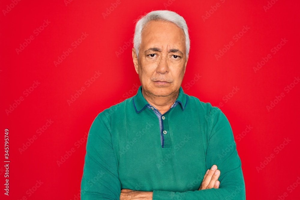 Sticker Middle age senior grey-haired man wearing casual sweater over red isoalted background skeptic and nervous, disapproving expression on face with crossed arms. Negative person.