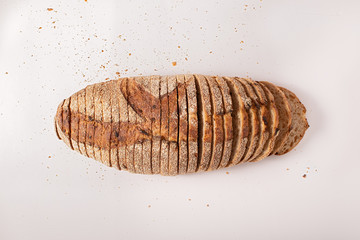 Sliced bread and crumbs on isolated white background, top view