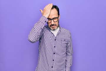 Middle age handsome man wearing casual shirt and glasses over isolated white background surprised with hand on head for mistake, remember error. Forgot, bad memory concept.