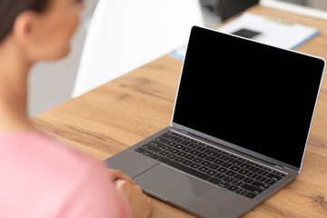 Woman working on laptop with blank black screen
