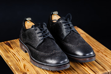 stylish leather black shoes against a dark background.