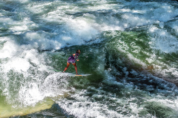 A girl surfing on wave in ocean, view from above.