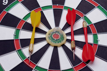 Unpacked condom on the background of a dartboard target (darts), toned