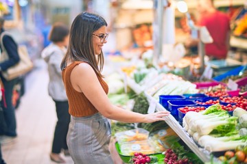 Young beautiful woman smiling happy and confident. Standing with smile on face buying food at supermarket