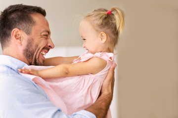 Millennial father holding his cute loving daughter