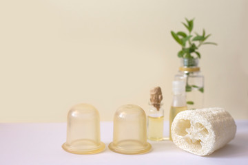 Silicone jars, loofah sponge and massage oil. Aaccessories for anti-cellulite and lymphatic body massage