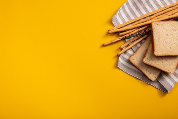 The bread on the table, breadsticks next to a square of bread on a colorful background. a lot of space