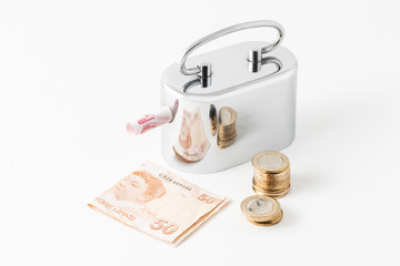 Silver metal money box, Turkish Lira banknote and coins.