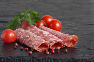 Meat platter with  sliced sausage, and tomatoes. Selective focus.