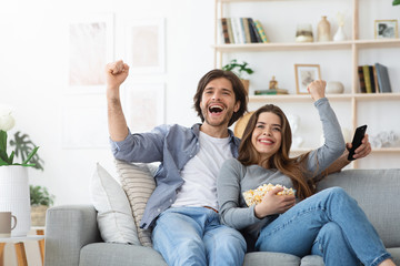 Emotional man and woman watching football game together