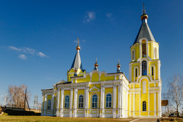Christian church on a background of blue sky. Golden domes of the Orthodox Cathedral.