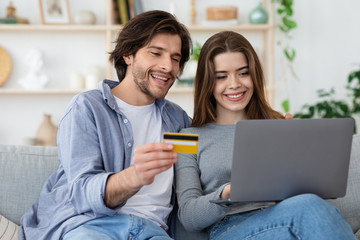 Positive couple using credit card for online shopping