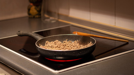 A vitroceramic with a pan cooking meat