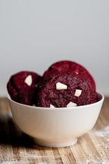 Red velvet cookies with white chocolate on wooden table with white background