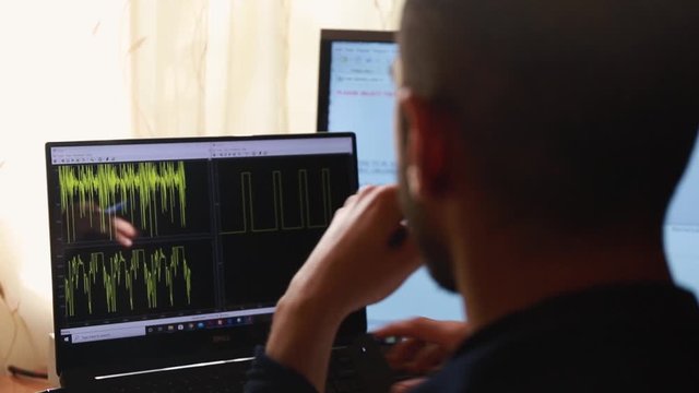 Young Caucasian man uses laptop computer to analyze numerical computing, Matlab concept